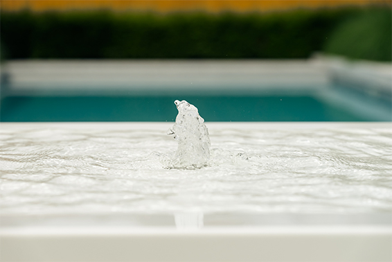 Dit moderne design waterelement zorgt voor een bijzondere sfeer bij dit zwembad.